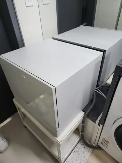 식기세척기 배수호스 연장 — 선반 위에 놓인 식기세척기